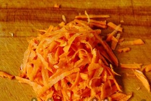 three carrots on a grater