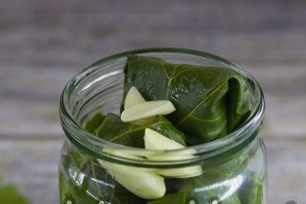 на следващия слой се разстила обелени скилидки чесън, черен и подправки грах