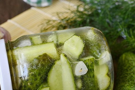 a jar of cucumbers with garlic